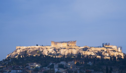 Athens, Attica, Greece. View towards the Acropolis on hilltop above Athens illuminated at dusk.