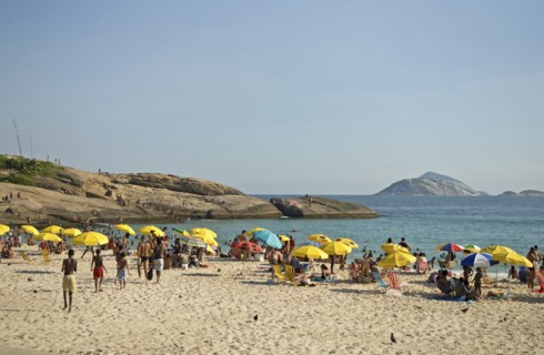 Rio de Janeiro, Brazil. Arpoador end of Ipanema beach with yellow umbrellas blue sea and sky