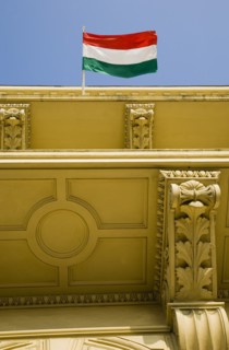 Budapest, Pest County, Hungary. Hungarian flag flying from partly seen rooftop of renovated