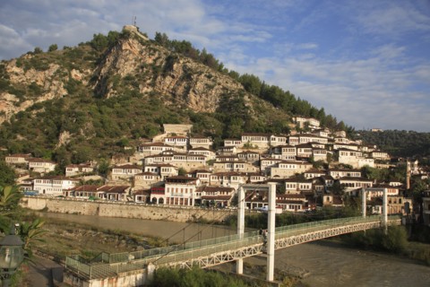 Albania, Berat, Traditional Ottoman buildings across hillside overlooking footbridge over the River