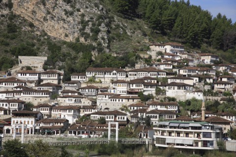 Albania, Berat, Traditional Ottoman buildings across hillside overlooking footbridge over the River