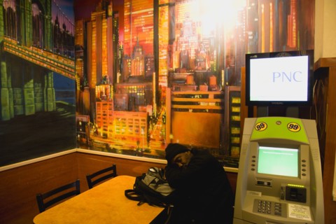 USA, New York, New York City, Manhattan  Man asleep at table beneath wall painting of Manhattan
