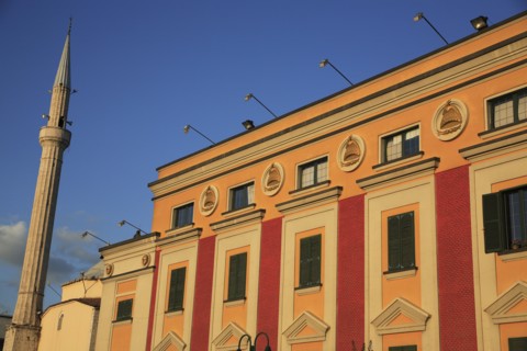 Albania, Tirane, Tirana, Pink and yellow government building facades beside minaret of Ethem Bey