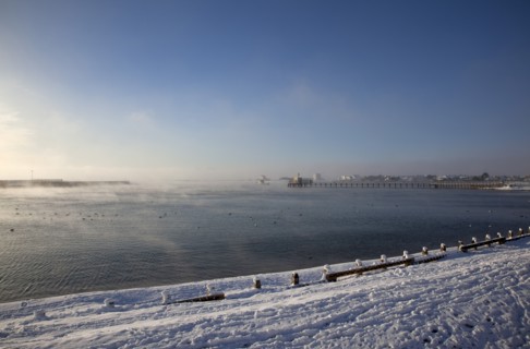 England, West Sussex, Shoreham-by-Sea , Mist rising from harbour waters on frosty morning with snow