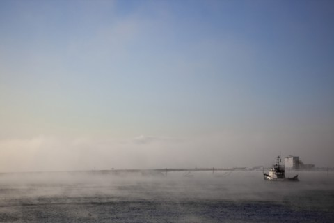 England, West Sussex, Shoreham-by-Sea , Mist rising from harbour waters on frosty morning with tug