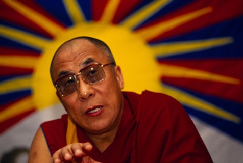 China, Tibet, Buddhism, The 14th Dalai Lama speaking to followers. Vibrant image of a yellow sun in