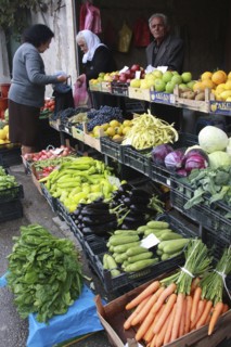 Albania, Tirane, Tirana, Customers and vendor beside display of fruit and vegetables at grocers in