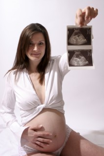 Health, Pregnancy, Scan, Young  pregnant woman holding up her ultrasound scan photograph with one