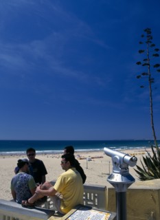 Portugal, Algarve, Praia da Rocha, View along beach with telescope and four young men in foreground