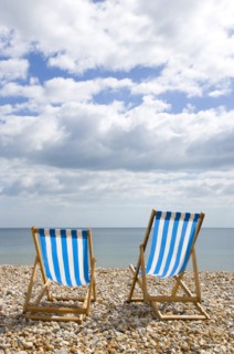 England, West Sussex, Bognor Regis, Two blue and white deck chair on the shingle pebble beach