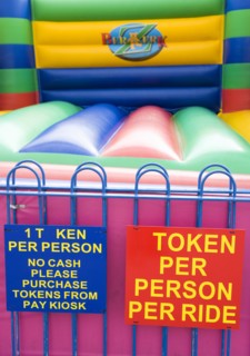 England, West Sussex, Bognor Regis, Empty colourful bouncy castle with signs on the Esplanade