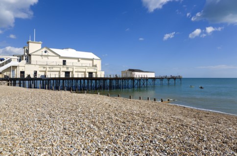 England, West Sussex, Bognor Regis, The Pier with people fishing off the end and the shingle pebble