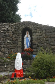 Ireland, General, Shrine in stone wall archway holding statue with flowers in front and statue of