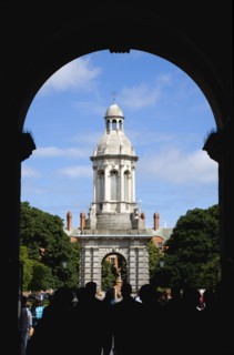 Ireland, County Dublin, Dublin City, Trinity College university with people walking through an arch
