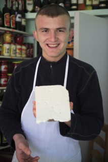 Albania, Tirane, Tirana, Young male cheese shop vendor in the Avni Rustemi Market wearing white