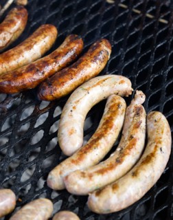 Food, Meat, Cooking, Sausages being cooked on a barbecue outdoor grill over hot coals.
