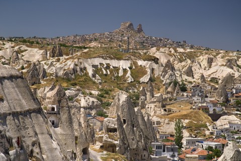 Cave hotel in foreground with view across volcanic tufa landscape towards hilltop town of Uchisar.