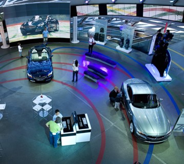BMW Welt. Elevated view over showroom floor with people examining BMW cars. Photo : Hugh Rooney