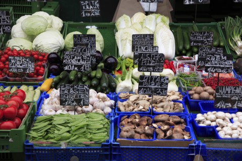 Vegetable stall in the Naschmarkt displaying produce including mushrooms tomatoes aubergine and