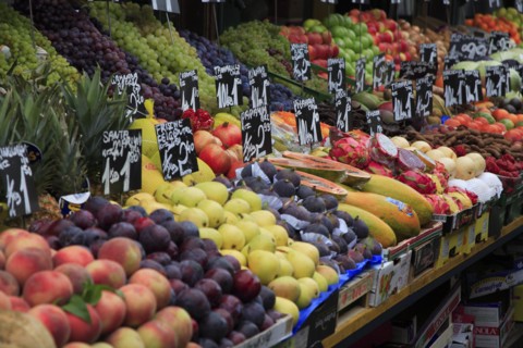 Fruit stall in the Naschmarkt with display of produce including peaches plums pears and figs.