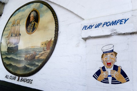 Wall paintings outside a tattooist parlour underneath railway arches at Portsmouth Harbour Station