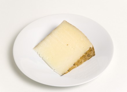 Slice of Spanish Manchego cheese made from pasteurised Manchega sheeps milk from the La Mancha