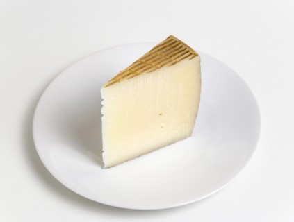 Slice of Spanish Manchego cheese made from pasteurised Manchega sheeps milk from the La Mancha
