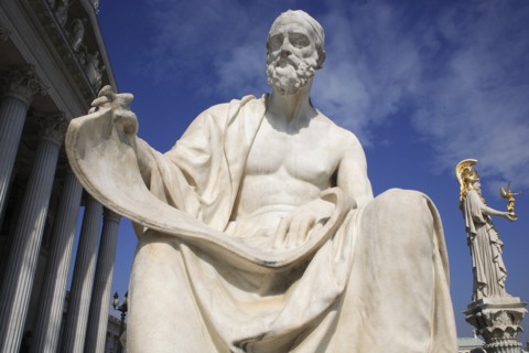 Statue of Polybius the Greek historian in front of Parliament building with statue of Athena in the