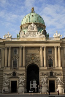 Hofburg Palace. Part view of exterior facade with domed roof above entrance archway.. Photo: