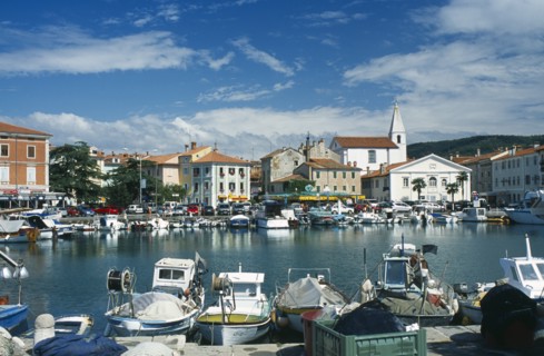 Port with fishing boats. Cars parked around the edge. Photo: Jonas Grau
