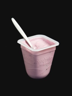 Yeo Valley probiotic blueberry fruit yogurt with spoon in pot against a black background. Photo :