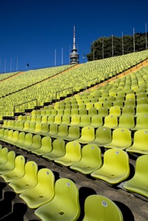Olympic Stadium. View across green seating of the stadium with part view of the Olympic Tower