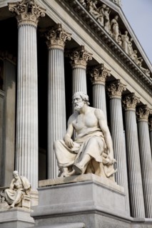 Part view of colonnaded exterior of the Parliament building with statue of the Greek philosopher