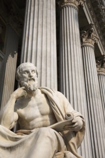 Statue of the Greek philosopher Herodotus in front of columns of the Parliament Building. Photo :