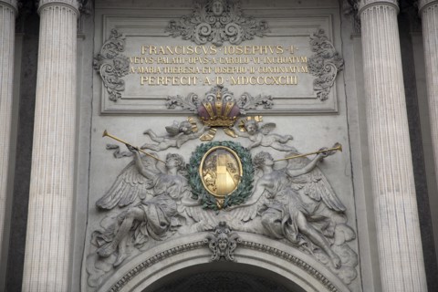 Inscription and sculpted figures above the Michaelertrakt gateway to the Hofburg Palace. Photo :