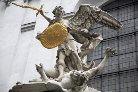 Sculpted figures above the entrance to St Michaels Church depicting St Michael slaying Lucifer by