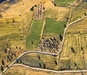 Aerial view over landscape and field patterns and branching road from hot air balloon. Photo: Hugh