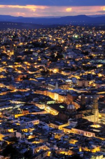 Mexico, Bajio, Zacatecas, View over city rooftops at night from Cerro de la Buffa. 
Photo : Nick