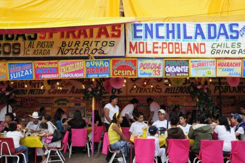 Mexico, Bajio, Zacatecas, Feria food stalls with customers eating on tables outside. 
Photo : Nick