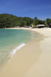 Mexico, Oaxaca, Huatulco, Bahia Santa Cruz View along stretch of sandy beach lined by restaurants