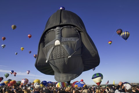 USA, New Mexico, Albuquerque, Annual balloon fiesta colourful hot air balloons in flight with darth