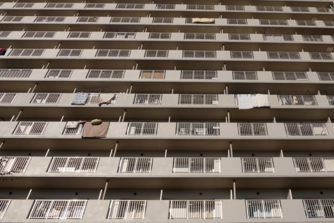 Japan, Honshu, Tokyo, Exterior or an apartment block with futon mattresses hung over balcony rails