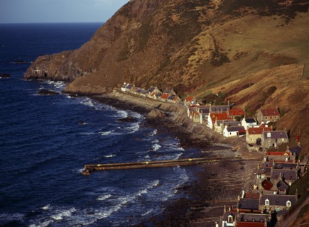 Scotland, Aberdeenshire, Crovie, One time fishing village seen from cliff top. Row of cottages at