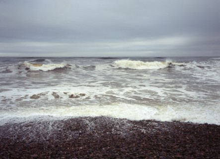 Scotland, Moray, Kingston, North facing shingle beach looking out across rough sea and surf.