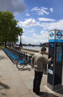 England, London, Vauxhall Albert Embankment of the river Thames man buying time on bicycle hire