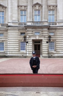 England, London, Westminster Buckingham Palace exterior with Police guard at the entrance. 
Photo