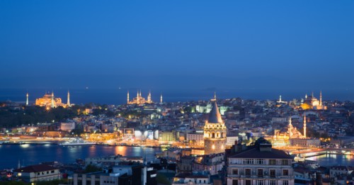 Turkey, Istanbul, View at sunset of illuminated city skyline from Beyoglu across rooftops to Galata