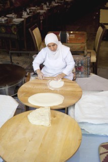 Turkey, Istanbul, Sultanahmet woman rolling out bread dough in restaurant. 
Photo : Stephen
