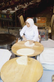 Turkey, Istanbul, Sultanahmet woman rolling out bread dough in restaurant. 
Photo : Stephen