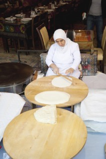 Turkey, Istanbul, Sultanahmet woman rolling out bread dough in restaurant. 
Photo : Stephen